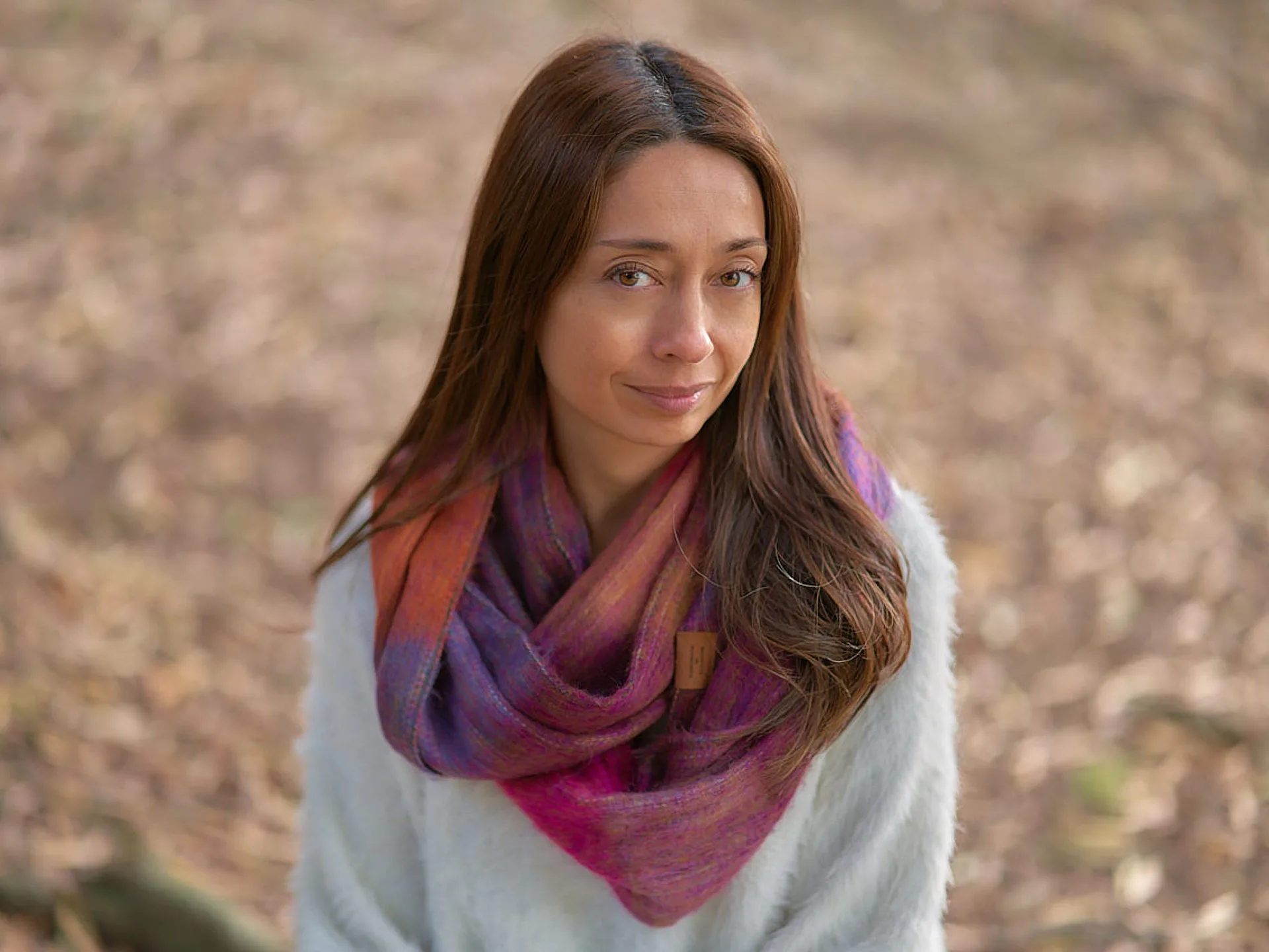 Woman wearing a handwoven striped scarf outdoors