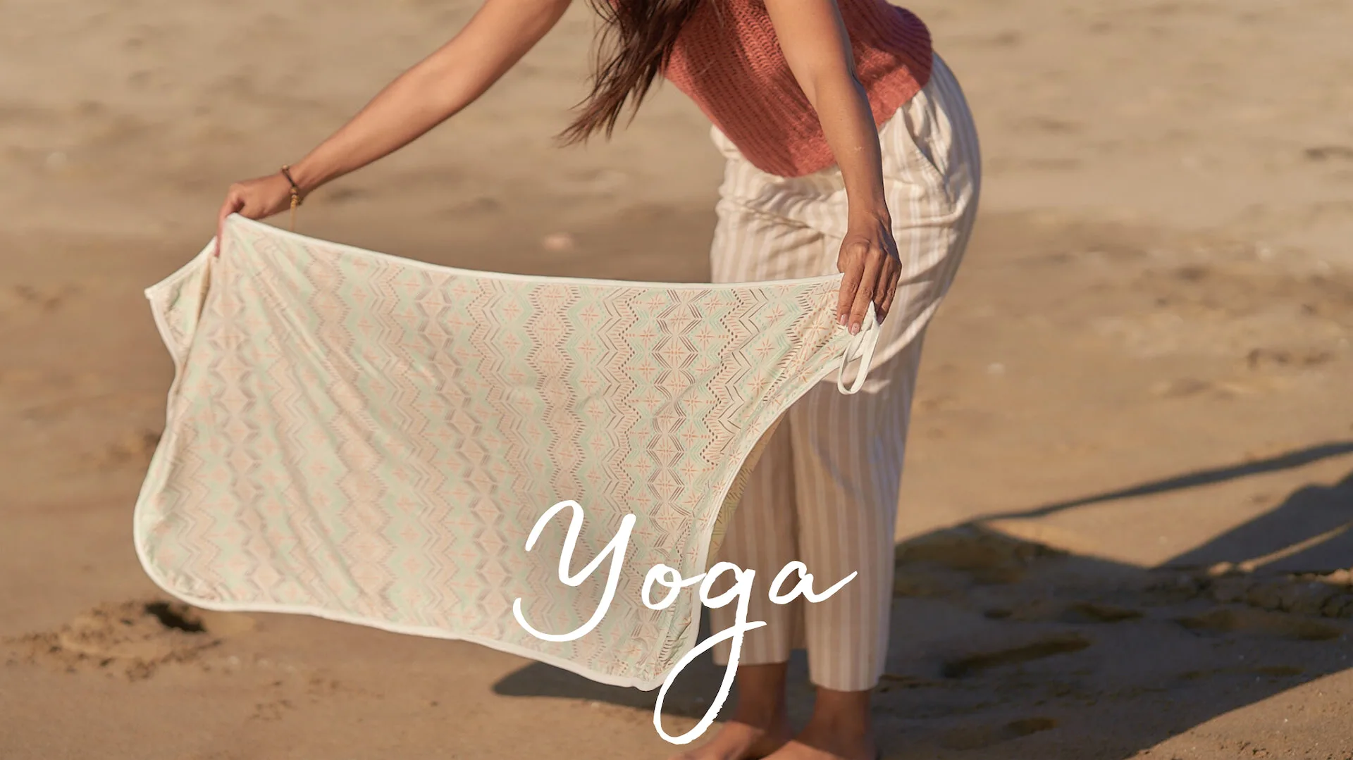 Yoga: woman folding a woven yoga blanket